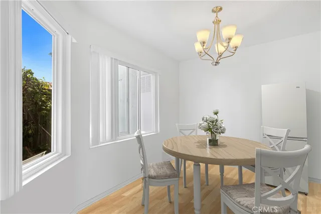 a view of a dining room with furniture a chandelier and wooden floor