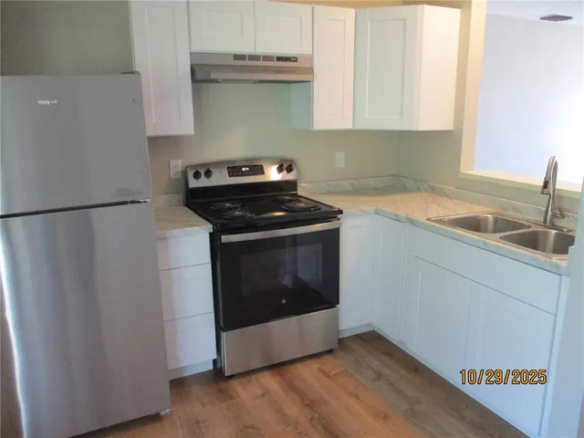 a kitchen with a stove top oven and cabinets