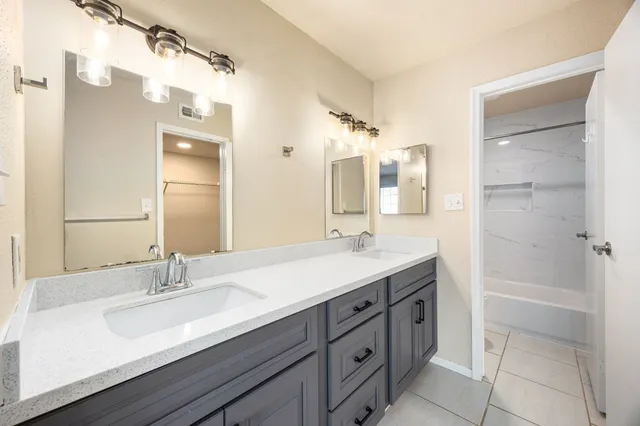 a bathroom with a double vanity sink a mirror and a shower
