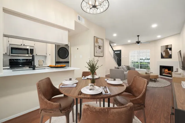 a view of a dining room with furniture a fireplace and wooden floor