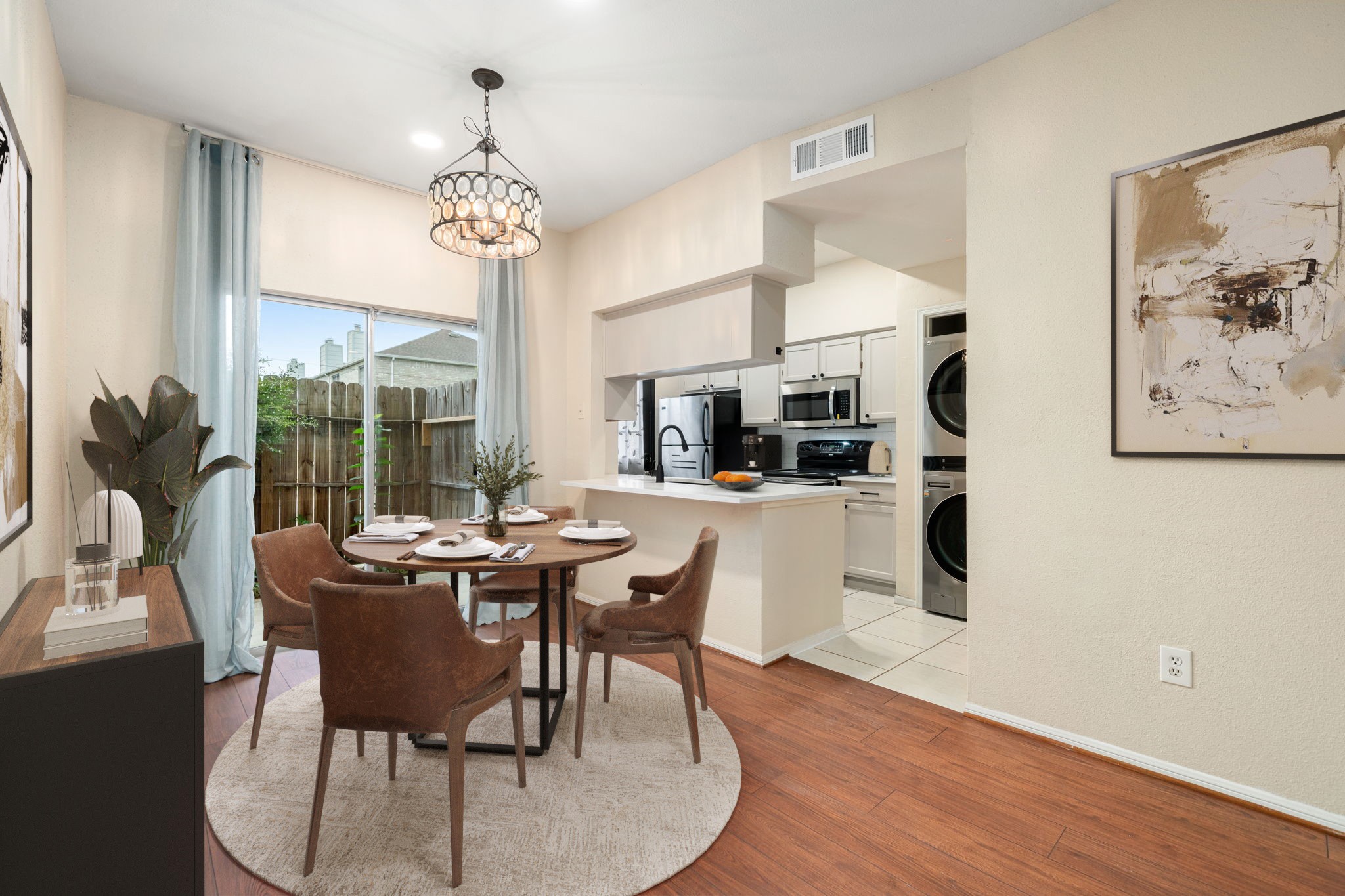7575 Cambridge Street, Unit 1604 Houston, TX 77054 - Photo 3 of 26 a dining room with wooden floor a chandelier a glass table and chairs