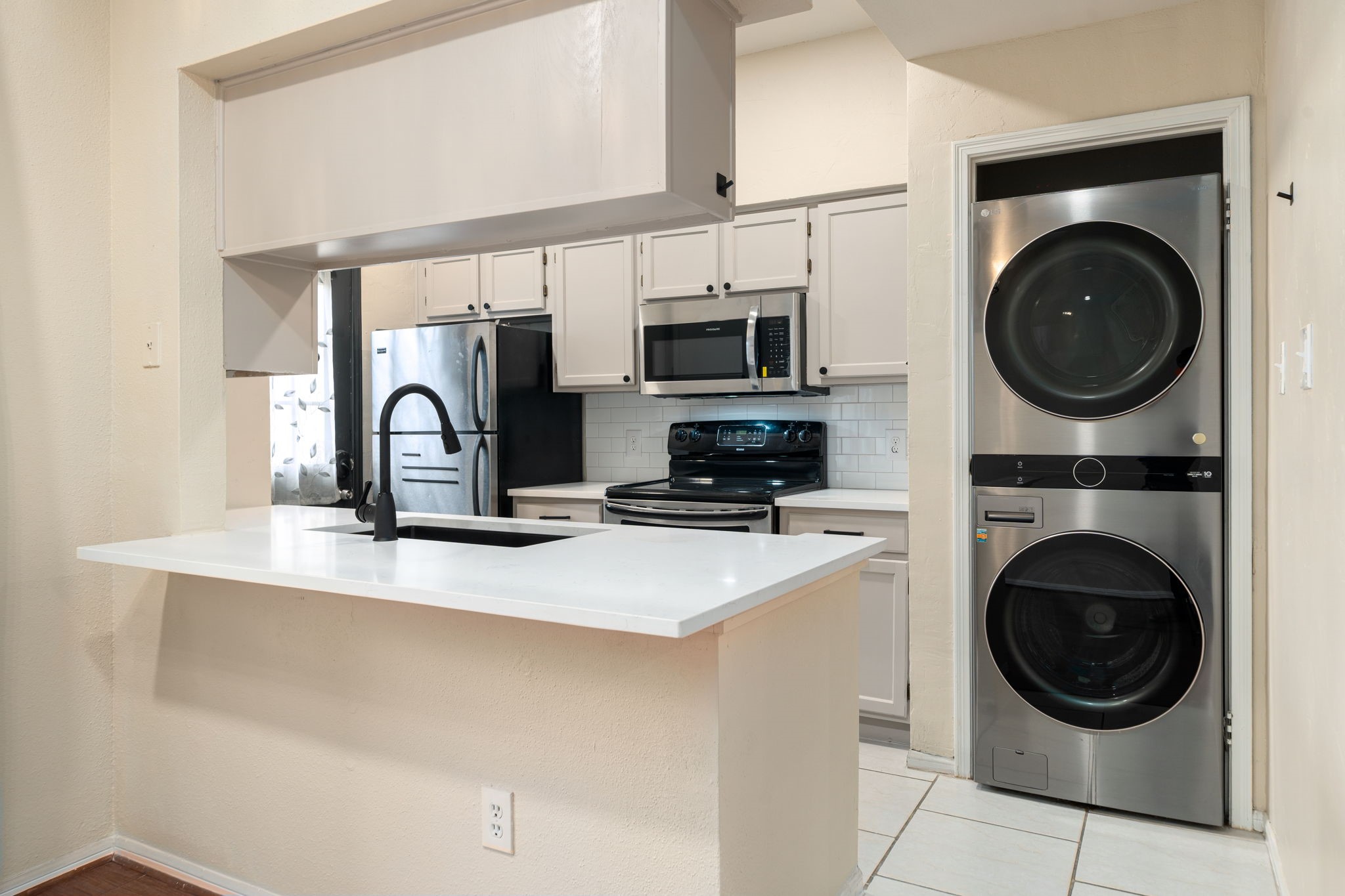 7575 Cambridge Street, Unit 1604 Houston, TX 77054 - Photo 7 of 26 a kitchen with stainless steel appliances a sink a stove a washer and dryer