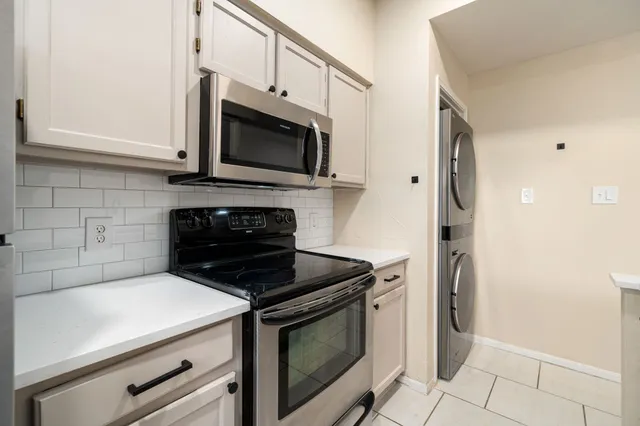a kitchen with stainless steel appliances a stove microwave and sink