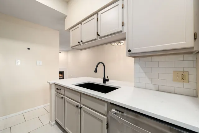 a close view of a sink a counter and dishwasher in a kitchen