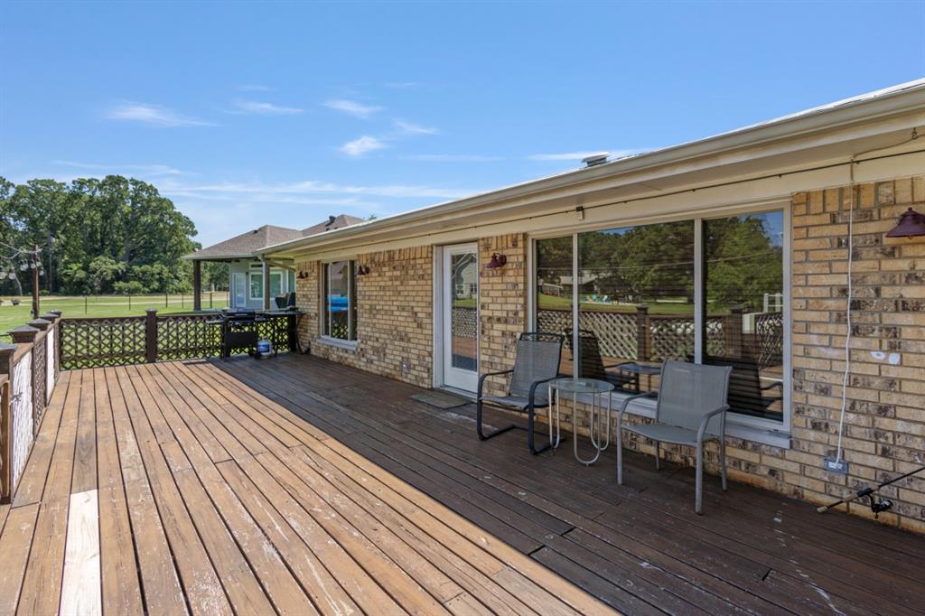 227 Scenic Road Trinidad, TX 75163 - Photo 24 of 40 a view of a deck with table and chairs with wooden floor and fence