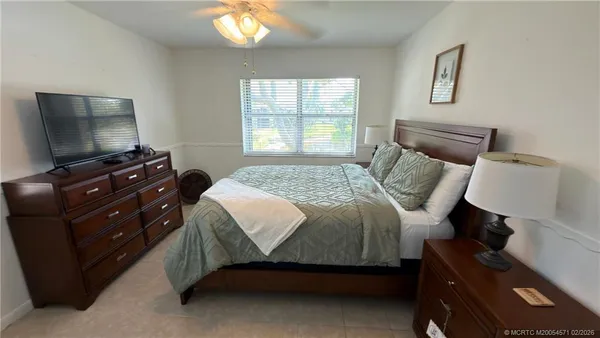 a bedroom with a bed and a flat tv screen on a dresser