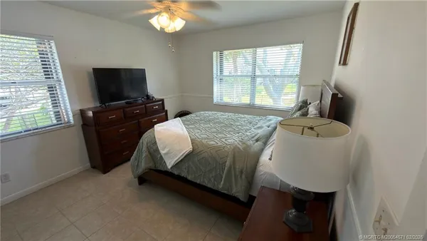 a bedroom with a bed and a flat tv screen on a dresser