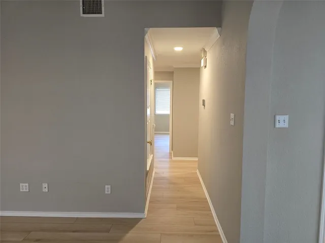 a view of a room with wooden floor and a hallway