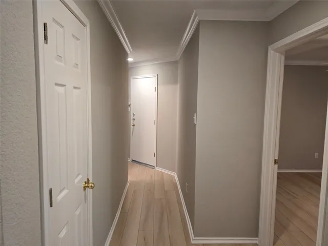 a view of a hallway with wooden floor and closet