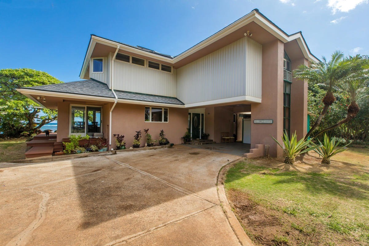 5040 Aliomanu Road Kilauea, HI 96754 - Photo 15 of 23 a front view of a house with a yard outdoor seating and garage