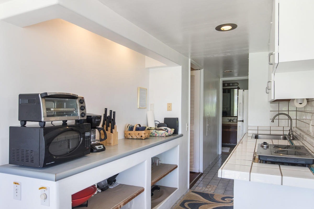 5040 Aliomanu Road Kilauea, HI 96754 - Photo 22 of 23 a kitchen with sink a stove and chairs