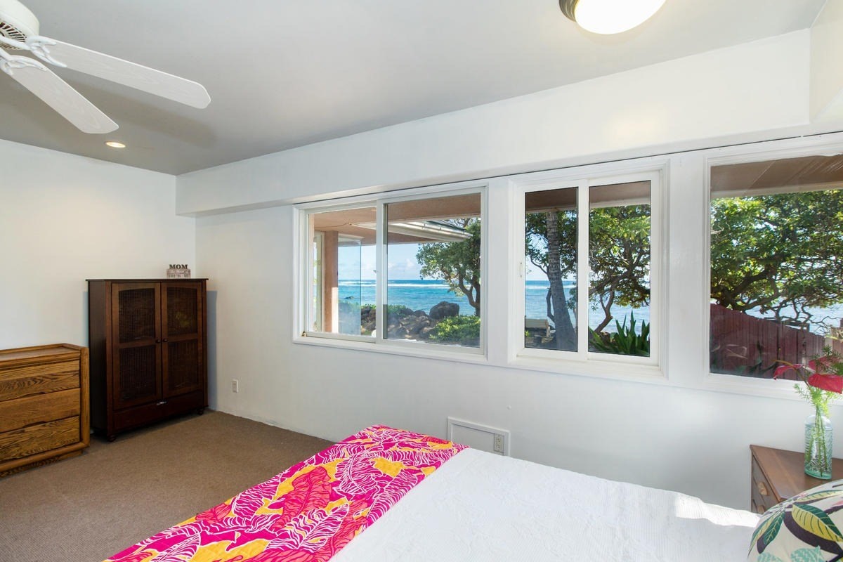 5040 Aliomanu Road Kilauea, HI 96754 - Photo 9 of 23 a bedroom with a bed and wooden floor