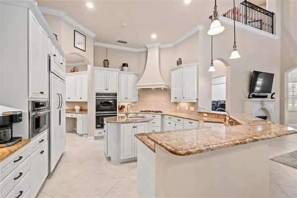 a large kitchen with kitchen island a dining table and chairs