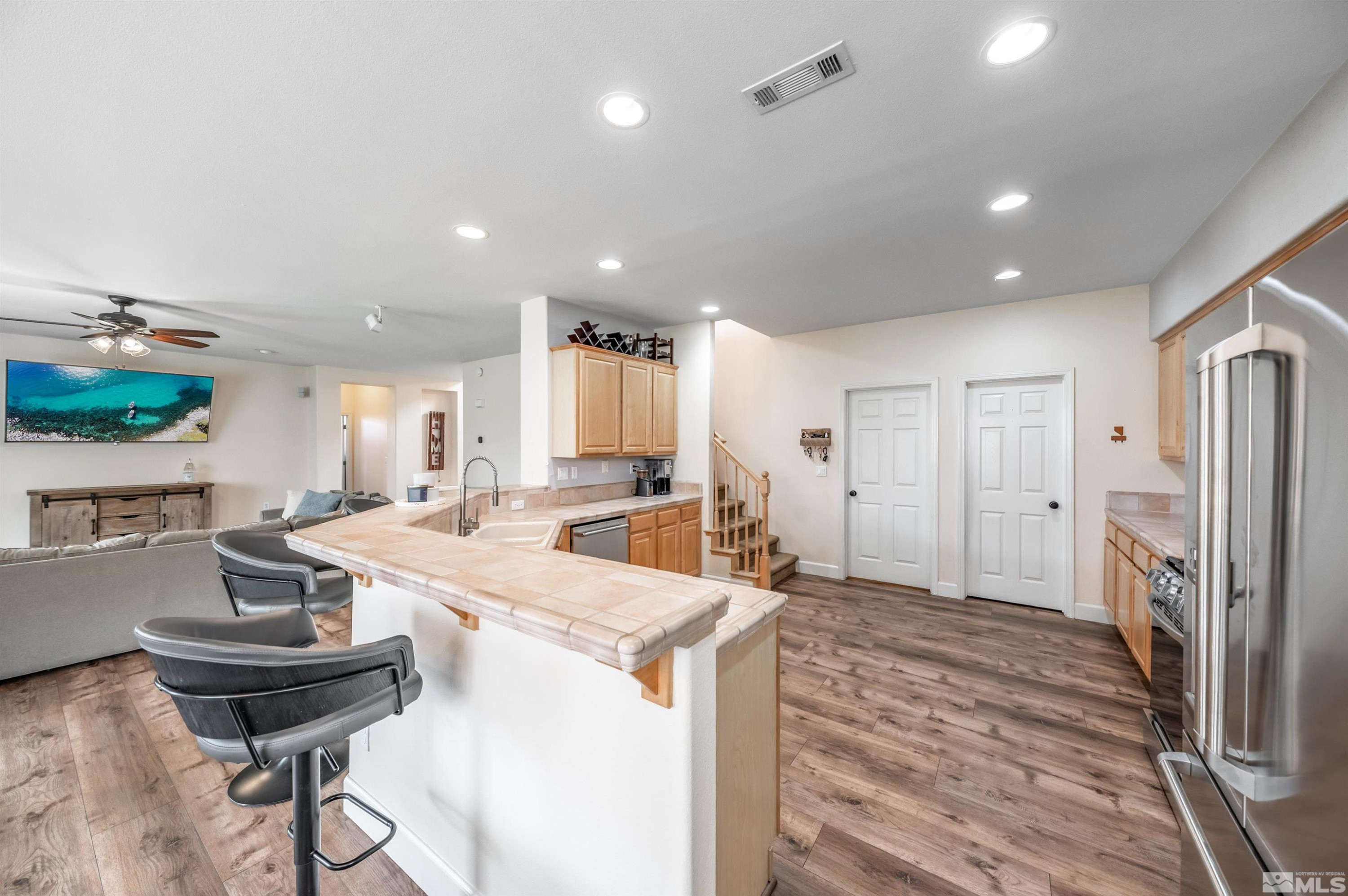 9915 Bandana Way Reno, NV 89521 - Photo 13 of 40 a kitchen with sink refrigerator dining table and chairs