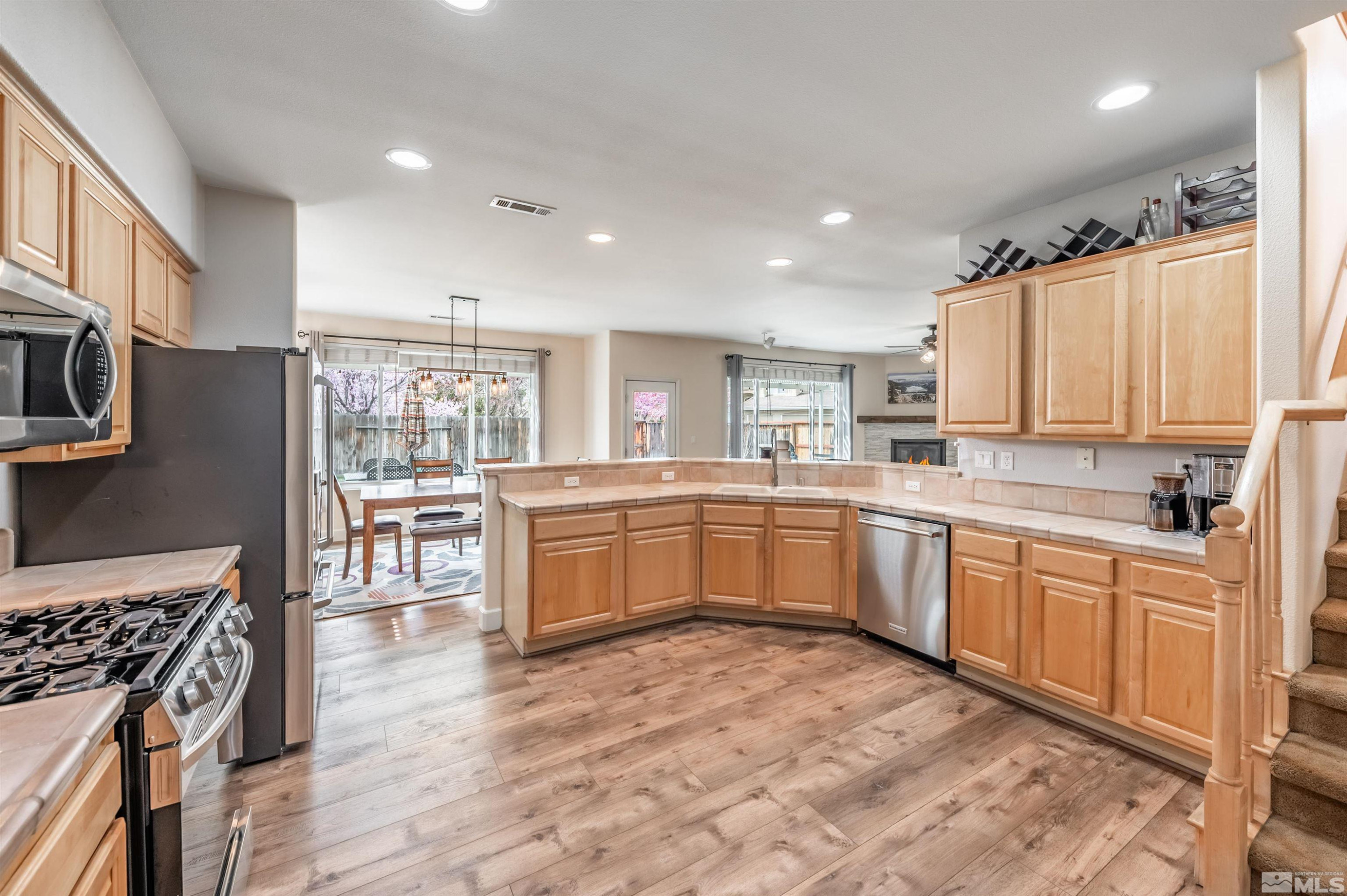9915 Bandana Way Reno, NV 89521 - Photo 17 of 40 a kitchen with a stove sink cabinets and wooden floor