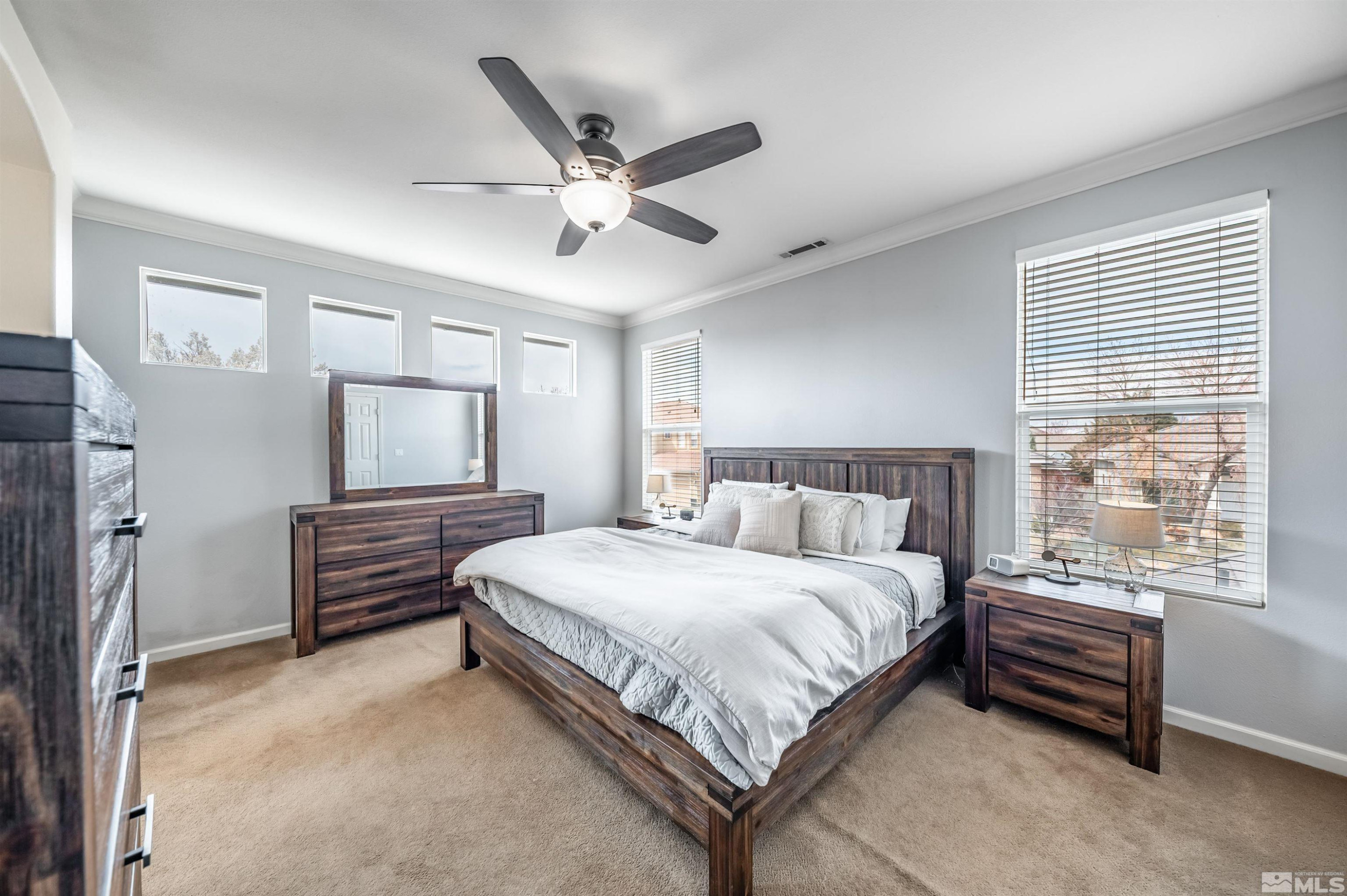 9915 Bandana Way Reno, NV 89521 - Photo 22 of 40 a bedroom with a large bed and a chandelier