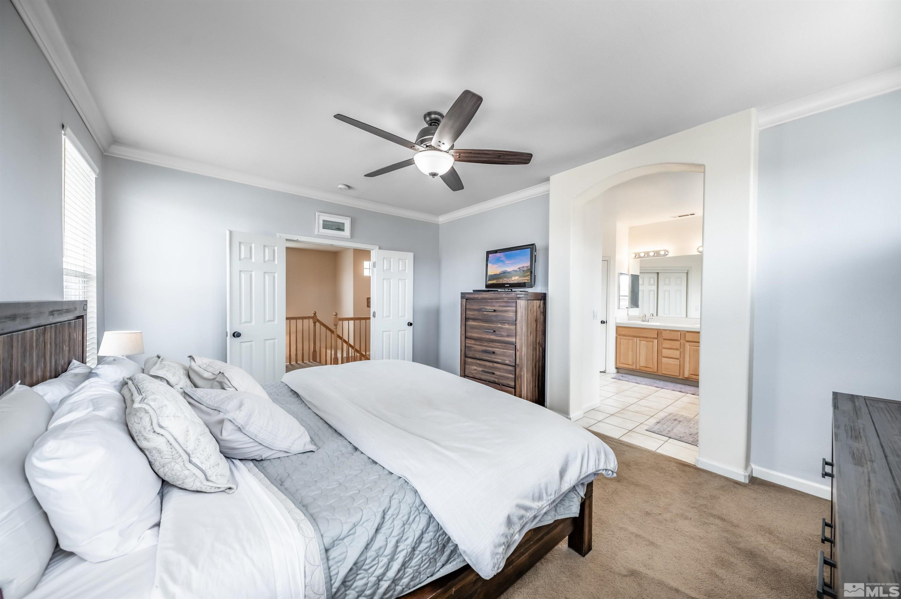 9915 Bandana Way Reno, NV 89521 - Photo 23 of 40 a bedroom with a large bed and a chandelier