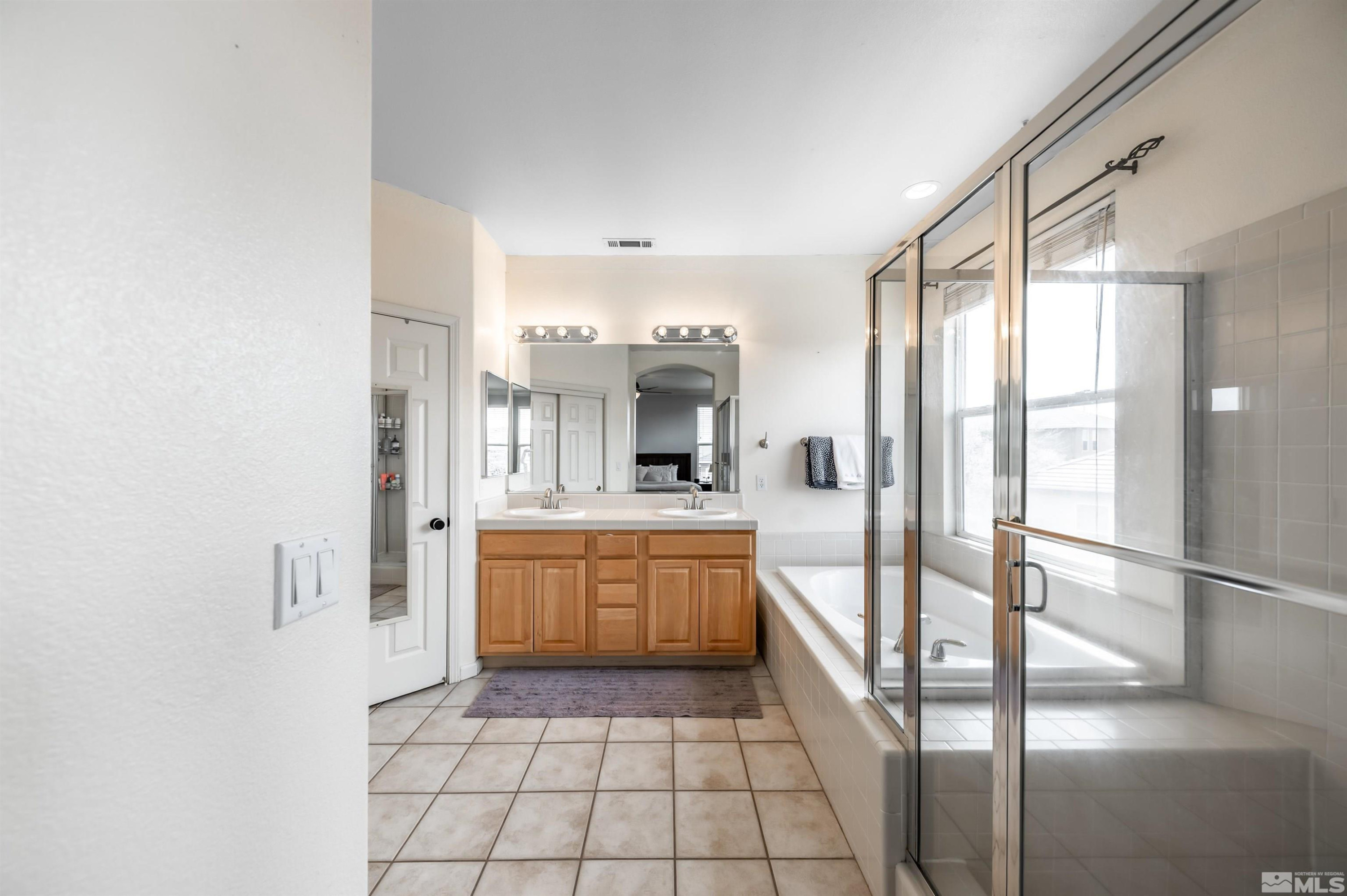 9915 Bandana Way Reno, NV 89521 - Photo 24 of 40 a large bathroom with a glass door shower and sink