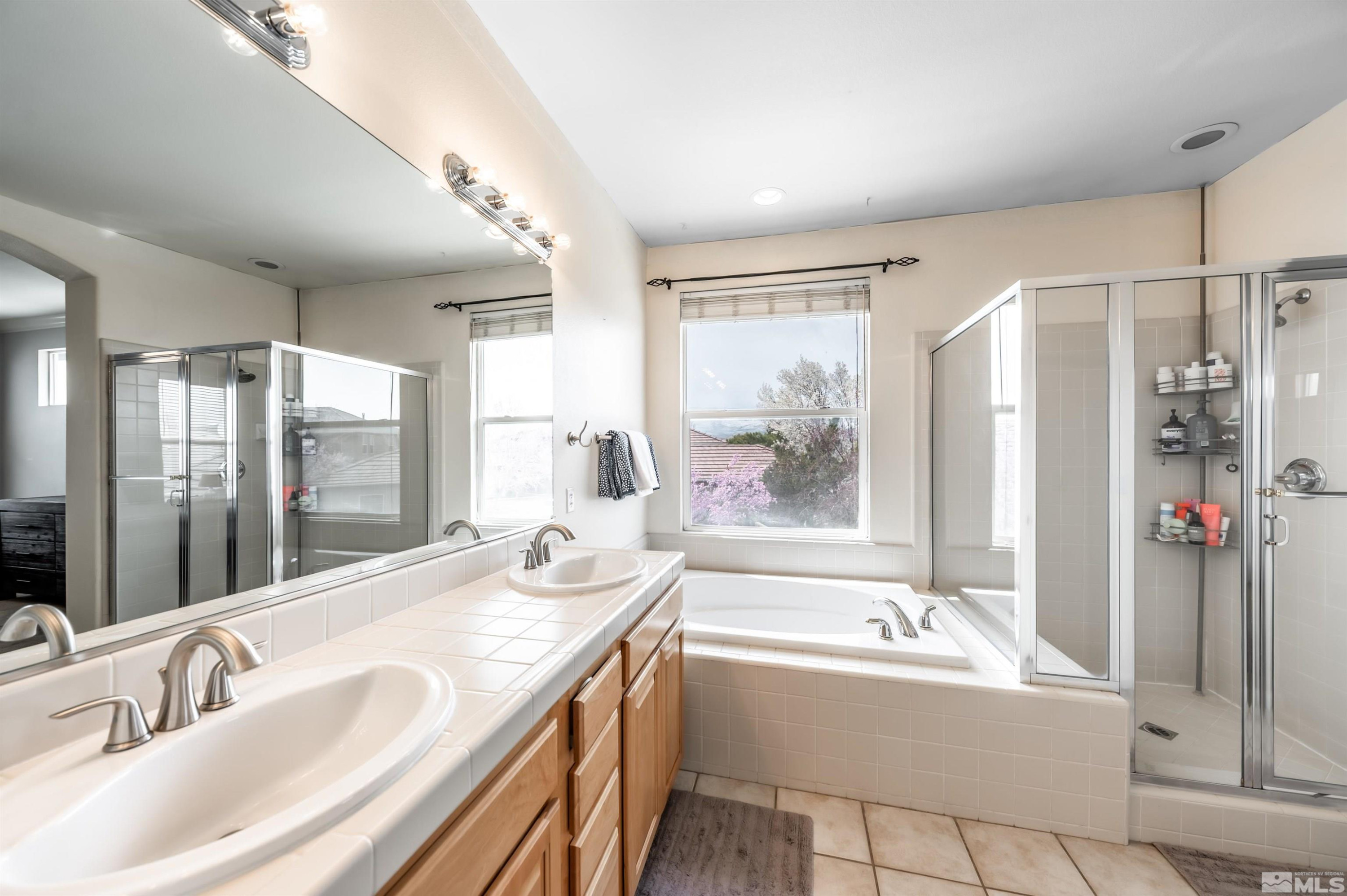 9915 Bandana Way Reno, NV 89521 - Photo 25 of 40 a spacious bathroom with a tub sink shower and mirror