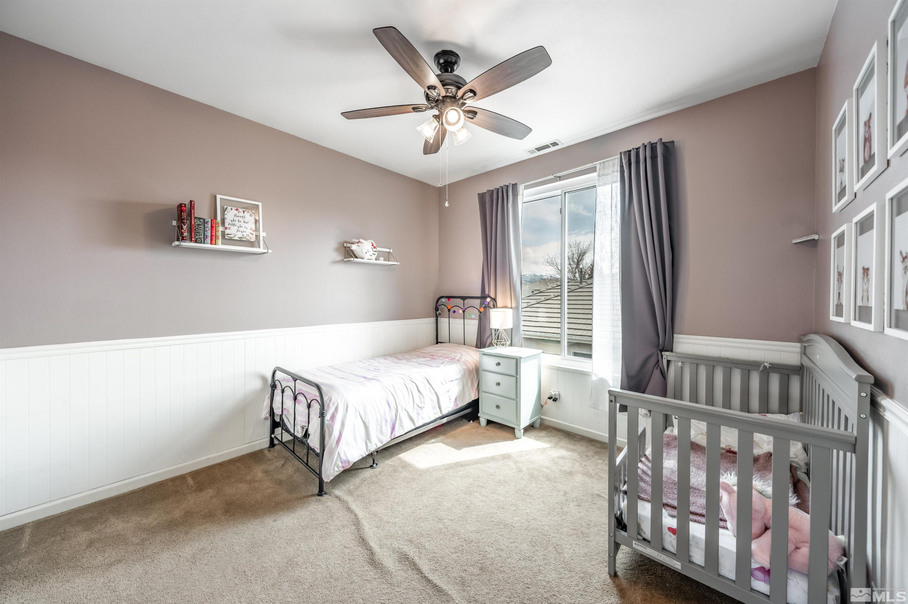 9915 Bandana Way Reno, NV 89521 - Photo 28 of 40 a spacious bedroom with a bed and a chandelier
