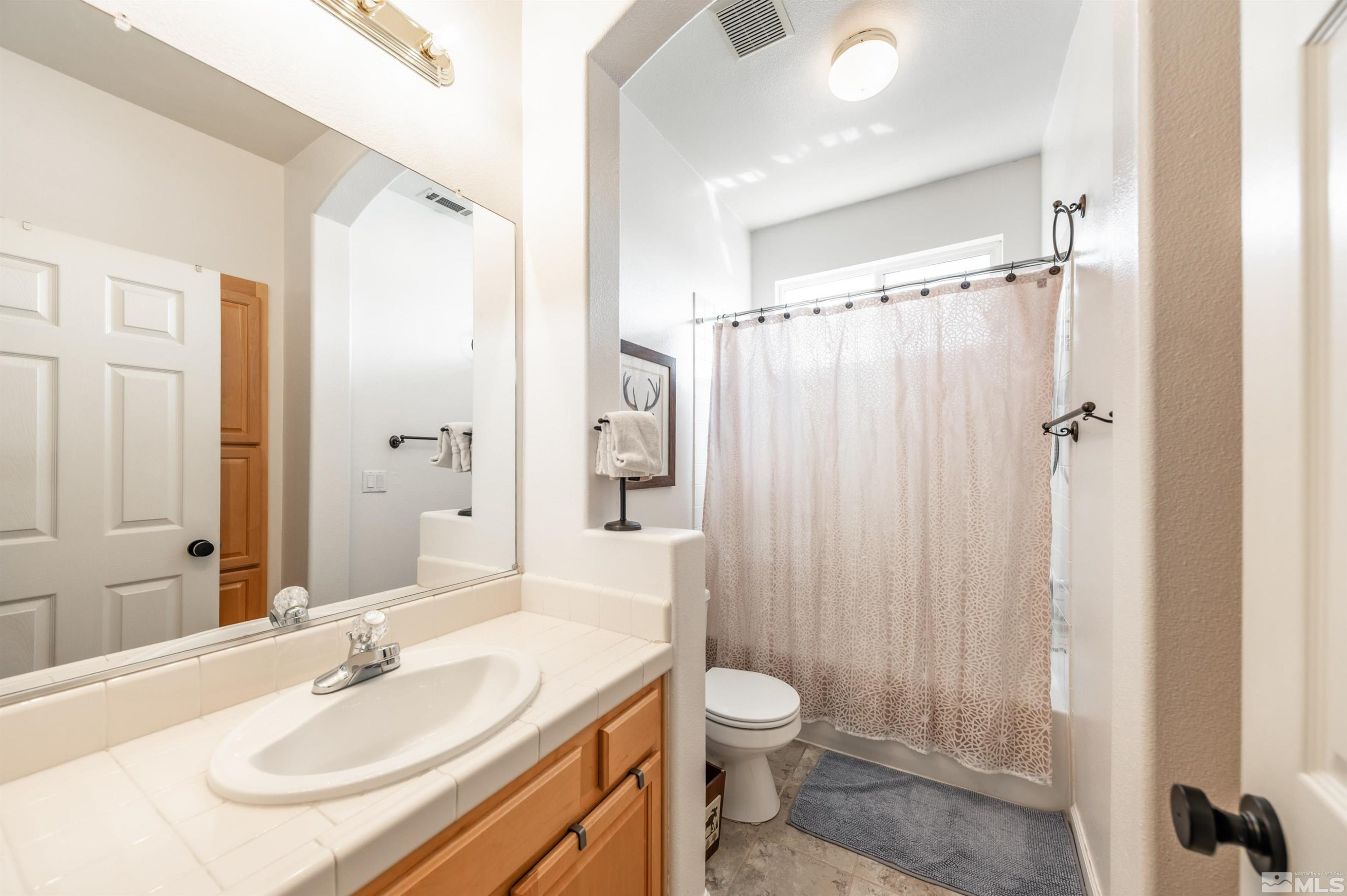 9915 Bandana Way Reno, NV 89521 - Photo 30 of 40 a bathroom with a sink toilet double vanity and shower