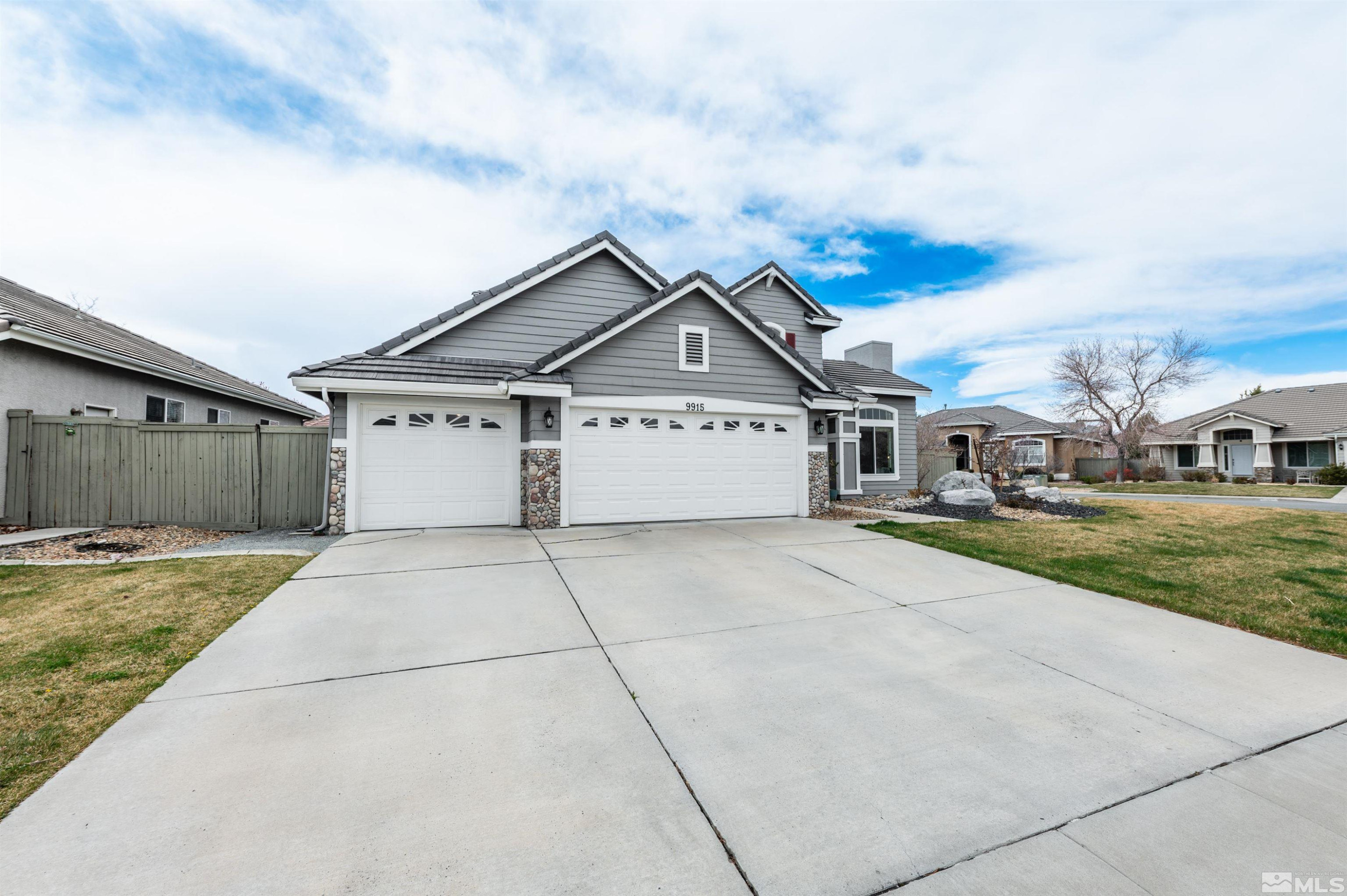 9915 Bandana Way Reno, NV 89521 - Photo 3 of 40 a front view of a house with a yard and garage