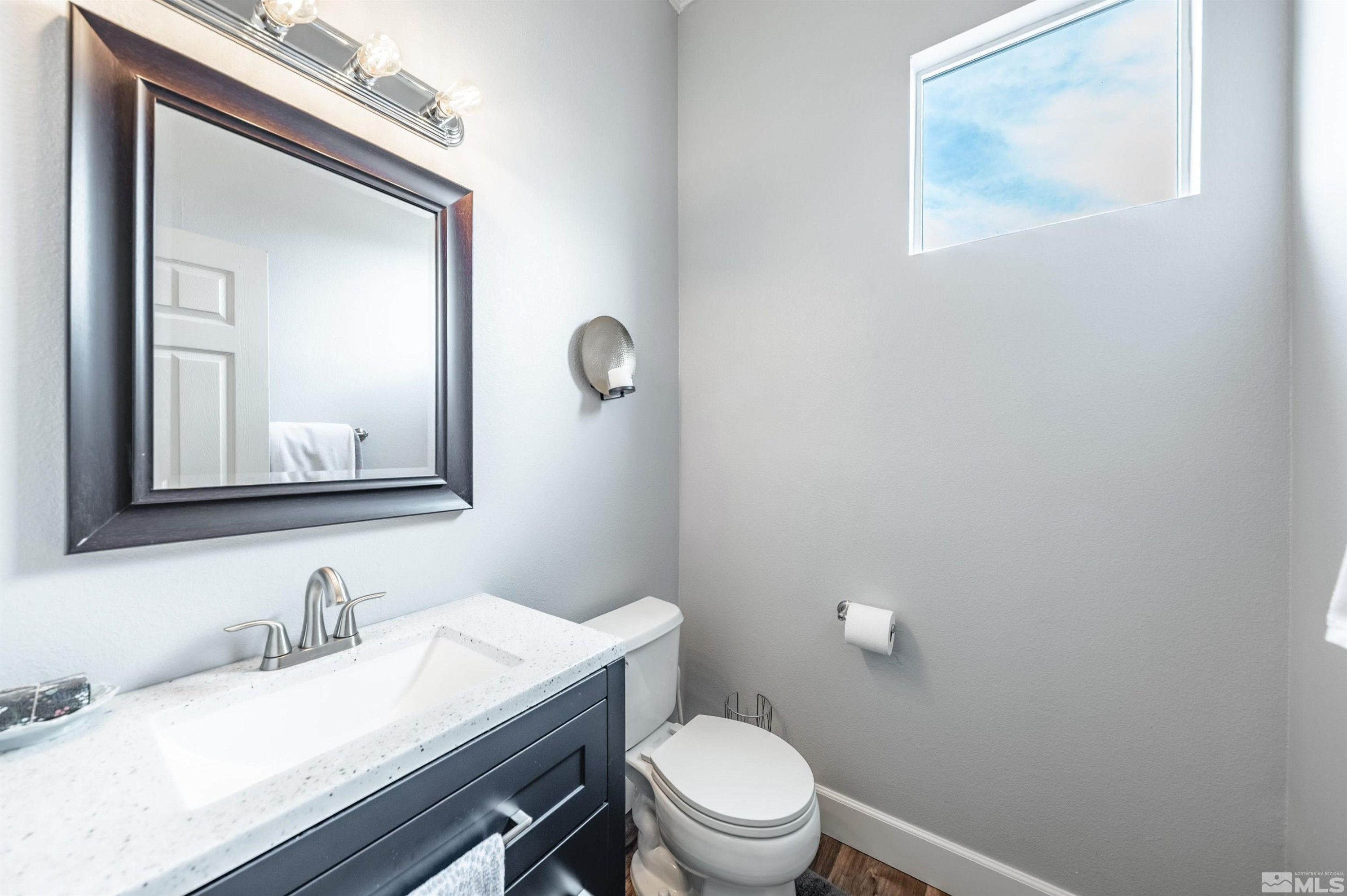9915 Bandana Way Reno, NV 89521 - Photo 31 of 40 a bathroom with a granite countertop toilet a sink and mirror