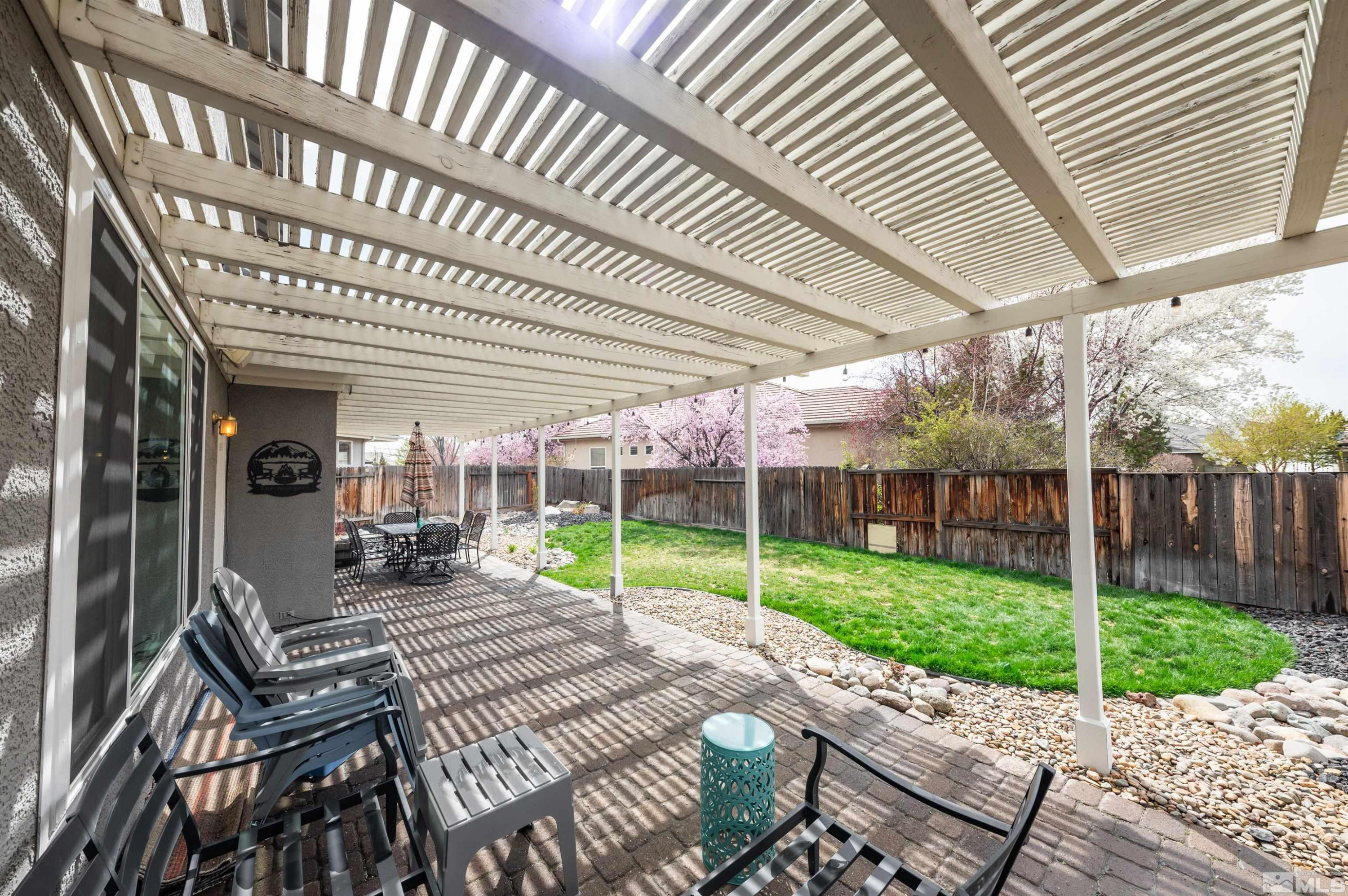 9915 Bandana Way Reno, NV 89521 - Photo 37 of 40 a view of a patio with a table chairs and wooden fence