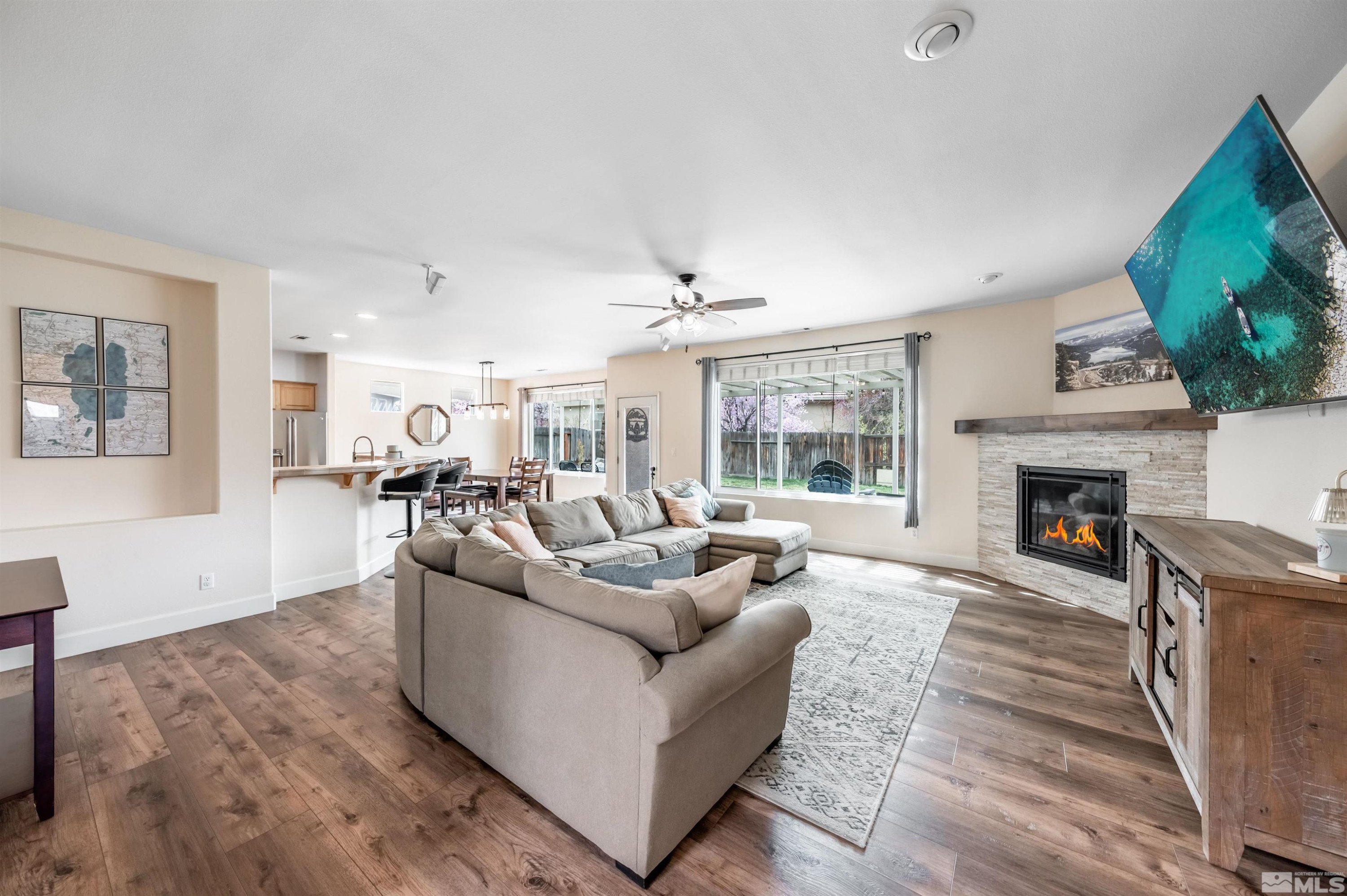 9915 Bandana Way Reno, NV 89521 - Photo 7 of 40 a living room with furniture a fireplace and a flat screen tv