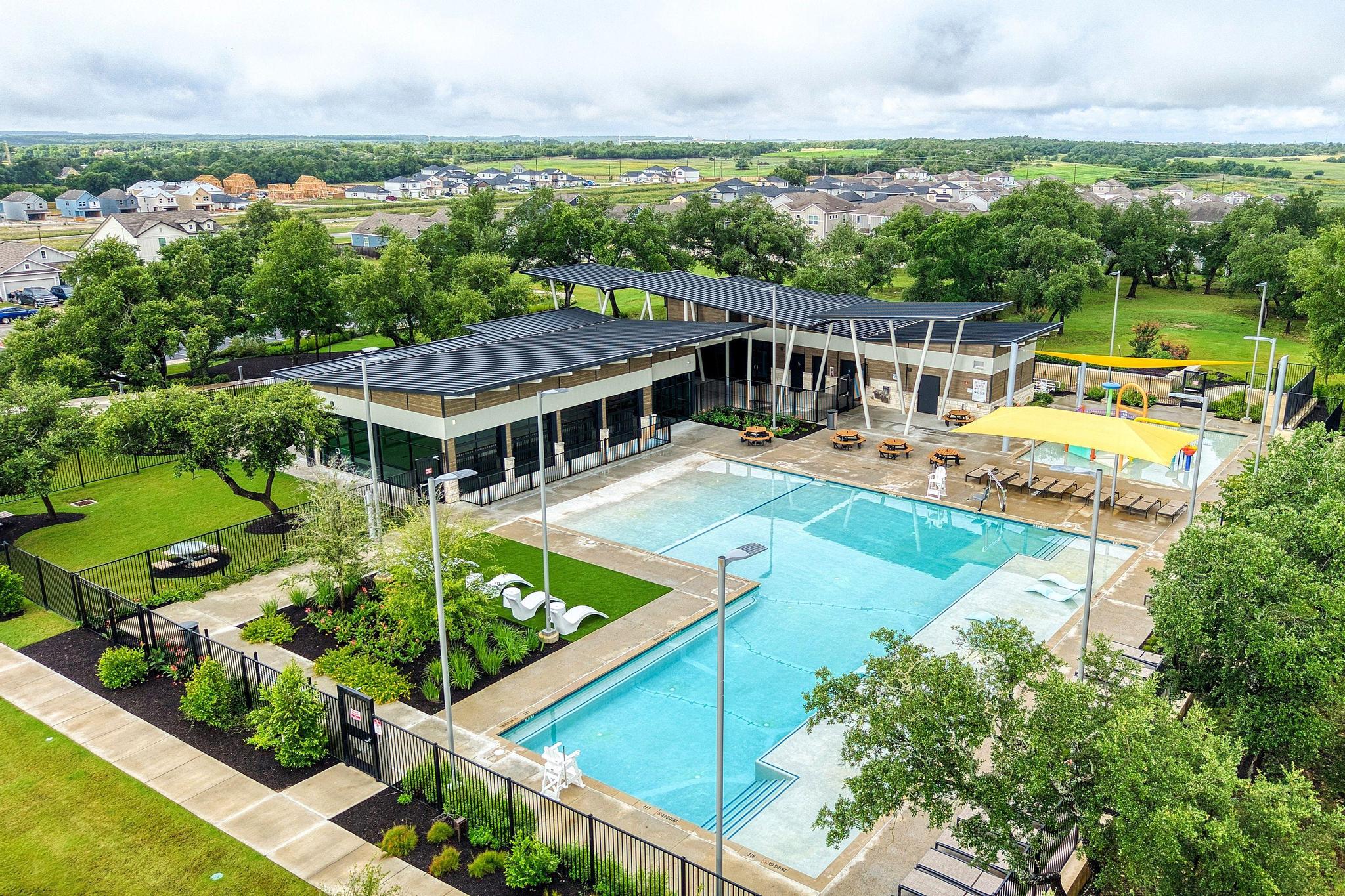 217 Innisfree Road Jarrell, TX 76537 - Photo 36 of 39 An aerial view captures the vibrant community amenities, featuring a sparkling pool, modern clubhouse, and abundant green space.