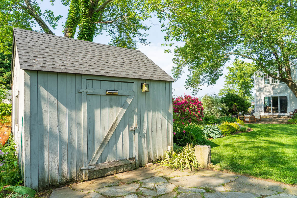 105 River Road Groton, CT 06355 - Photo 15 of 39 a view of a wooden house with a small yard and large trees