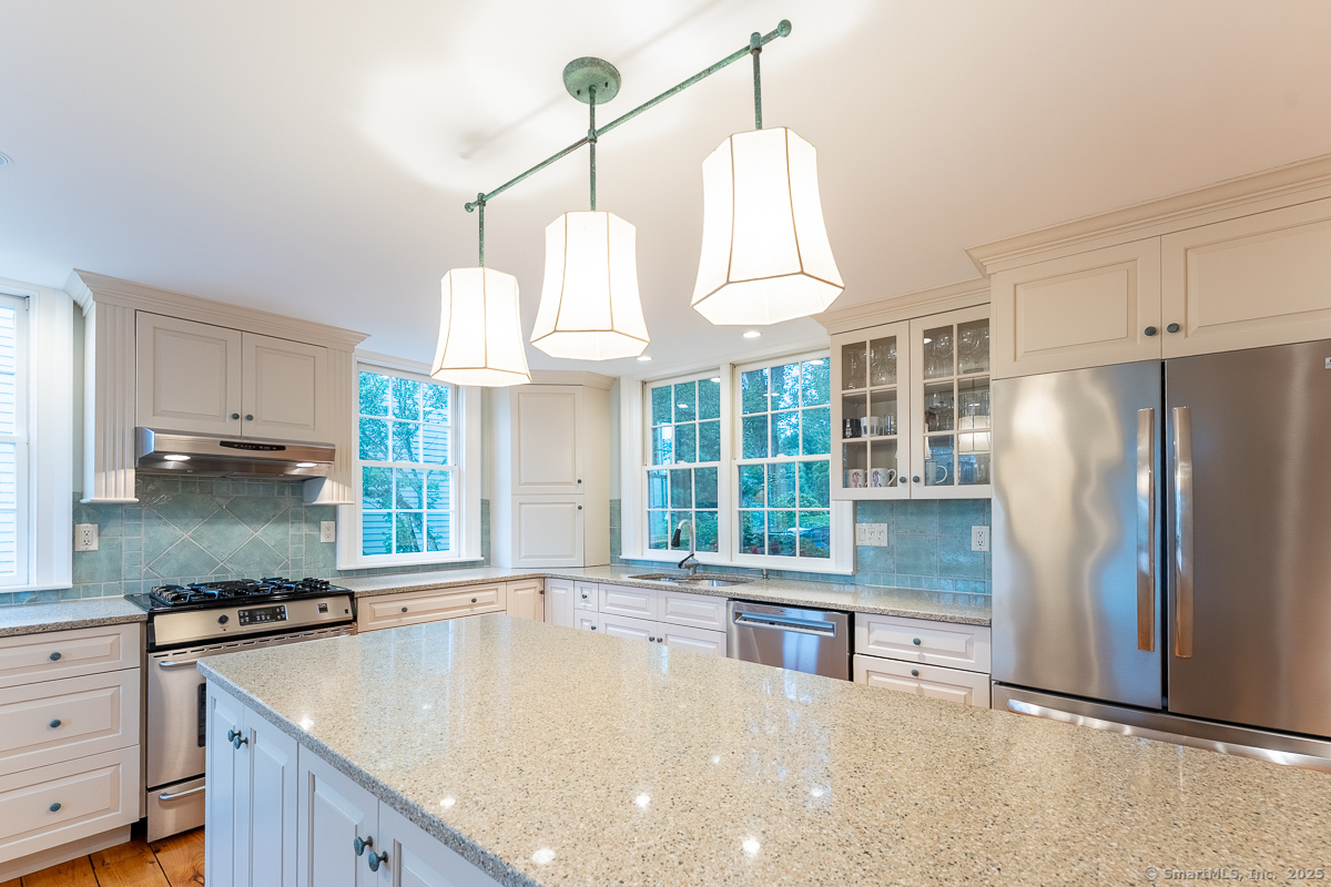 105 River Road Groton, CT 06355 - Photo 19 of 39 a kitchen with granite countertop a sink a counter space appliances and cabinets