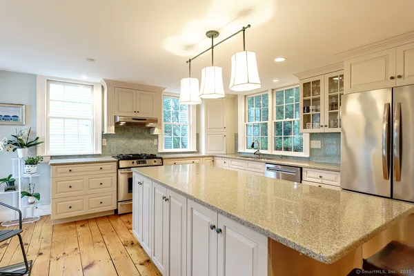 a kitchen with stainless steel appliances granite countertop a sink a stove and refrigerator