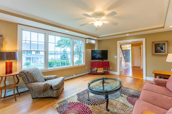 a living room with furniture a rug and a floor to ceiling window