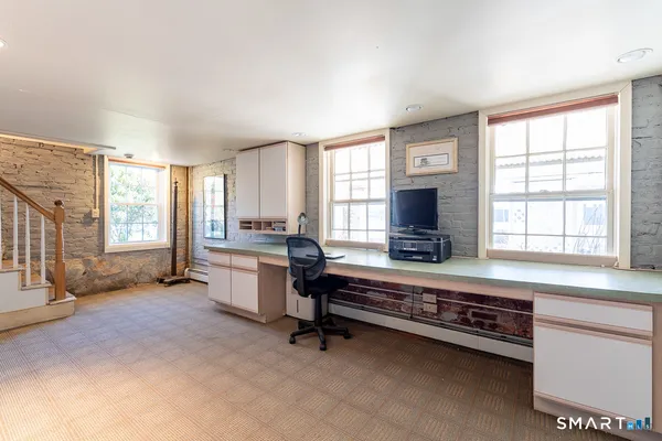 a living room with furniture flat screen tv and windows