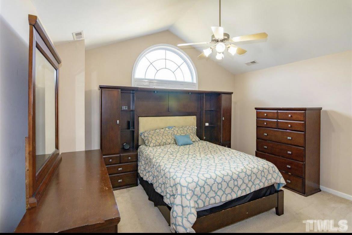 6810 Spanglers Spring Way Raleigh, NC 27610 - Photo 8 of 24 a bedroom with a bed and a chandelier