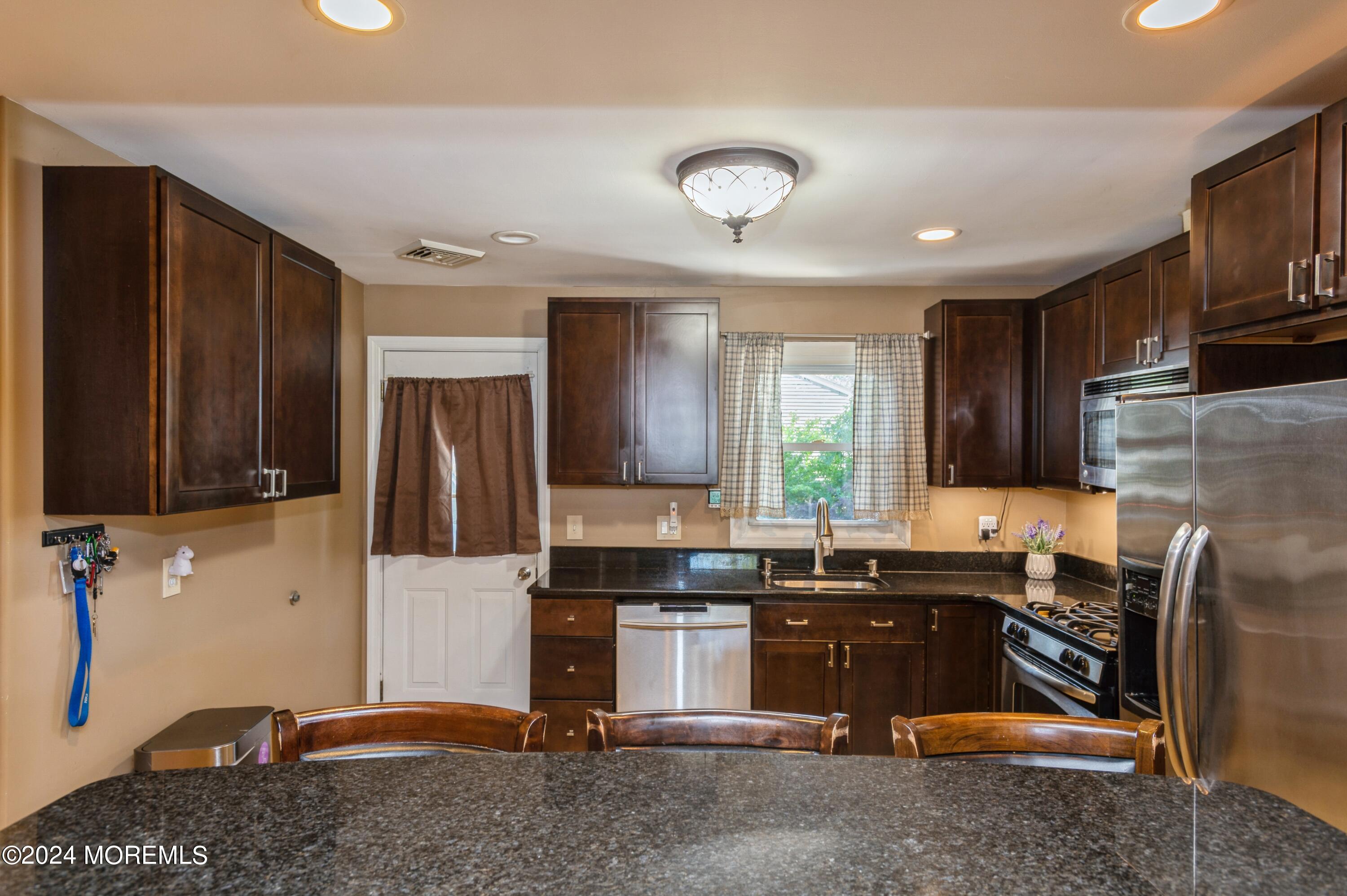 62 Capri Drive Brick, NJ 08723 - Photo 9 of 22 a kitchen with sink refrigerator and cabinets
