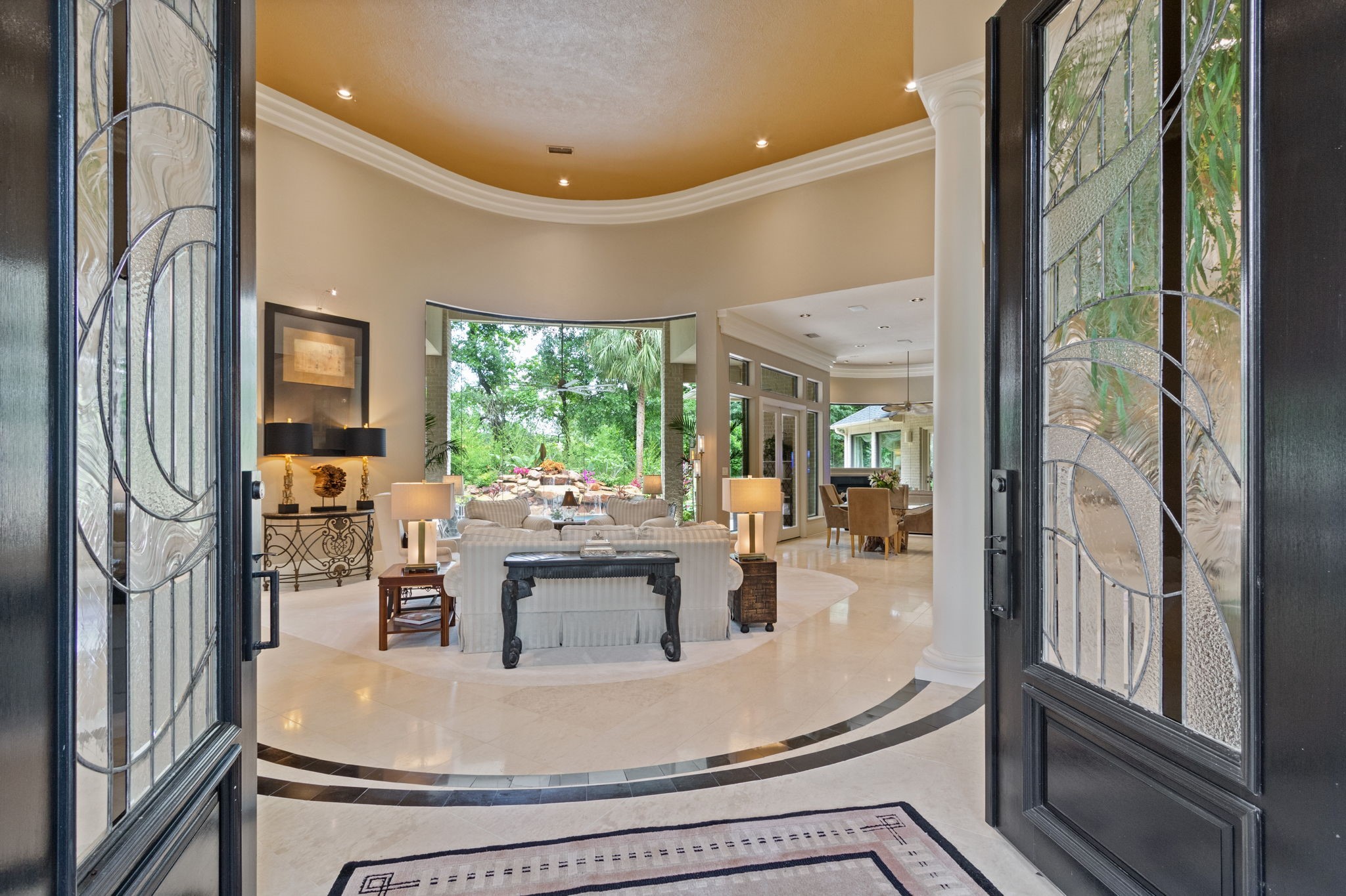17511 Seidel Road Tomball, TX 77377 - Photo 11 of 49 This elegant entryway showcases double doors leading into a spacious, open-plan living area with large windows offering lush garden views. The interior features high ceilings, polished floors, creating a welcoming and luxurious atmosphere.