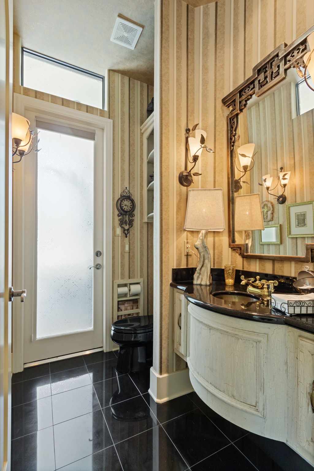 17511 Seidel Road Tomball, TX 77377 - Photo 16 of 49 Chic pool bathroom with elegant striped wallpaper and a black countertop. Features a stylish black toilet, ornate mirror, and ample lighting. Frosted glass door provides natural light and privacy. Perfect blend of modern and classic design.