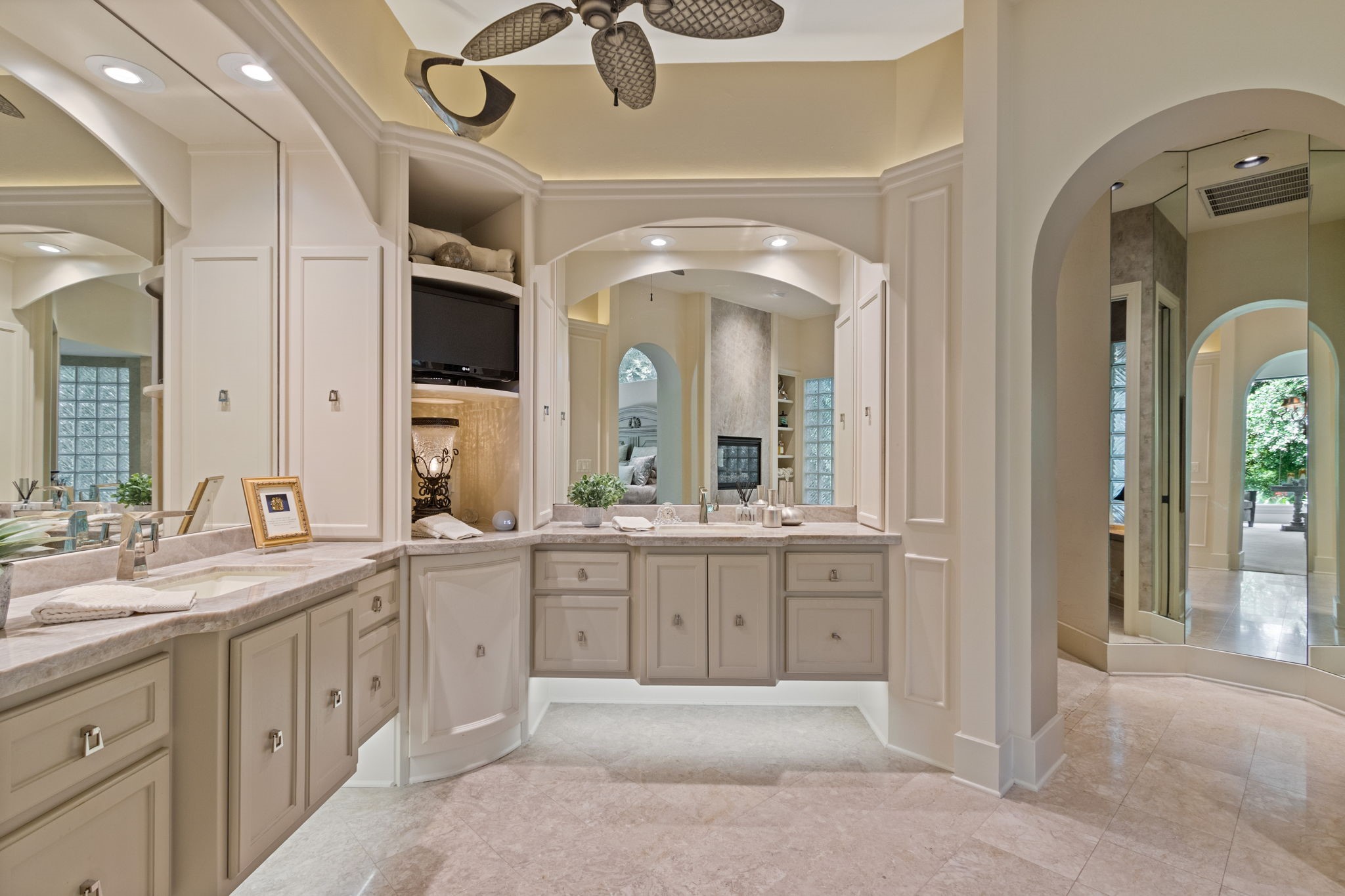 17511 Seidel Road Tomball, TX 77377 - Photo 27 of 49 This elegant expansive bathroom features dual vanities with ample storage, gorgeous Taj Mahal Quartzite counters and a ceiling fan. The neutral color palette and arched doorways complement the spacious and well-lit design, creating a luxurious atmosphere.