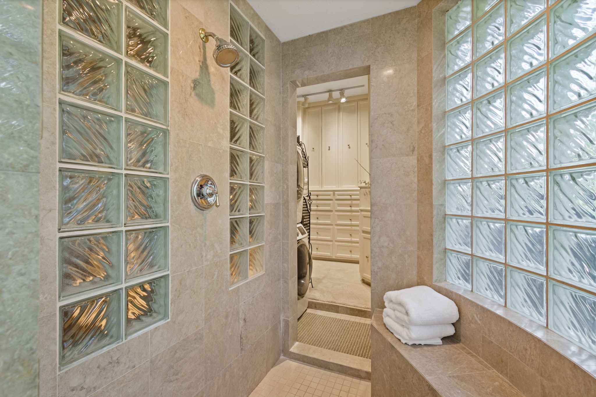 17511 Seidel Road Tomball, TX 77377 - Photo 29 of 49 Experience luxury with this spacious walk-through shower, featuring bench seating and a large shower head. It seamlessly connects to a private utility area and dressing space.