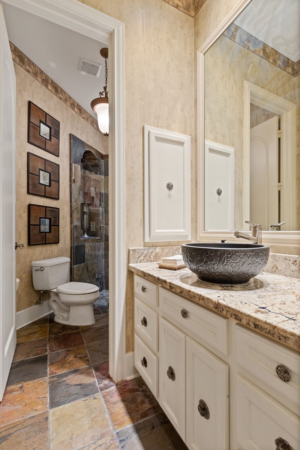 17511 Seidel Road Tomball, TX 77377 - Photo 36 of 49 This private bathroom off of the third suite features a stylish vessel sink on a granite countertop, with ample cabinetry for storage. It has tiled floors and a shower with slate-like wall tiles, creating a modern and earthy ambiance. Soft lighting enhance the cozy, elegant feel.