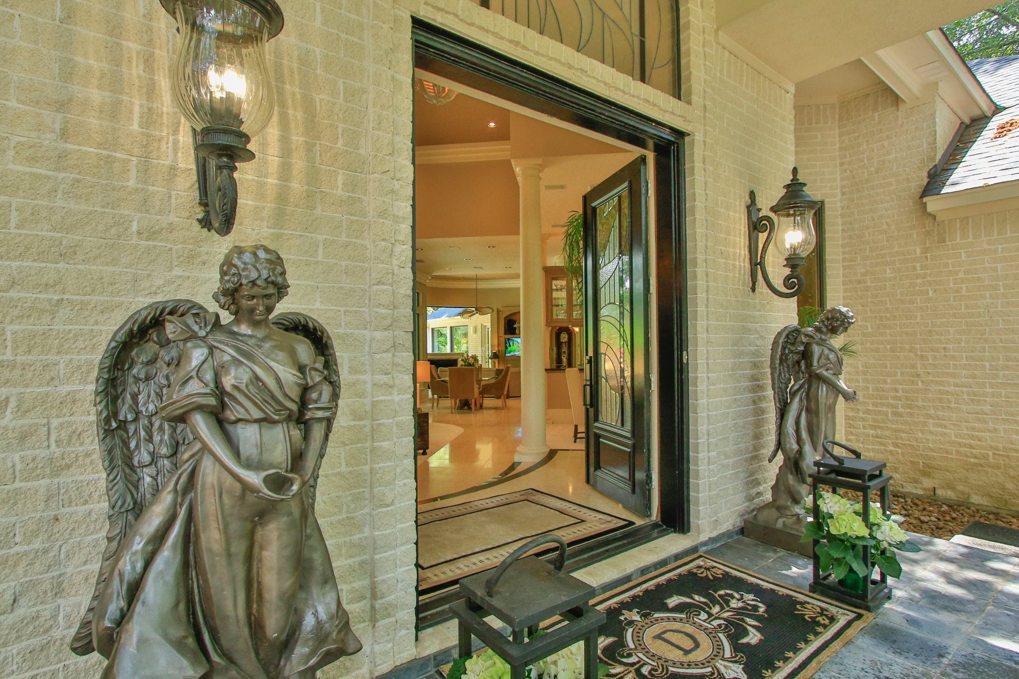 17511 Seidel Road Tomball, TX 77377 - Photo 45 of 49 Elegant entrance with ornate lighting, leading through the double doors to a spacious, warmly lit interior with high ceilings and a welcoming atmosphere.