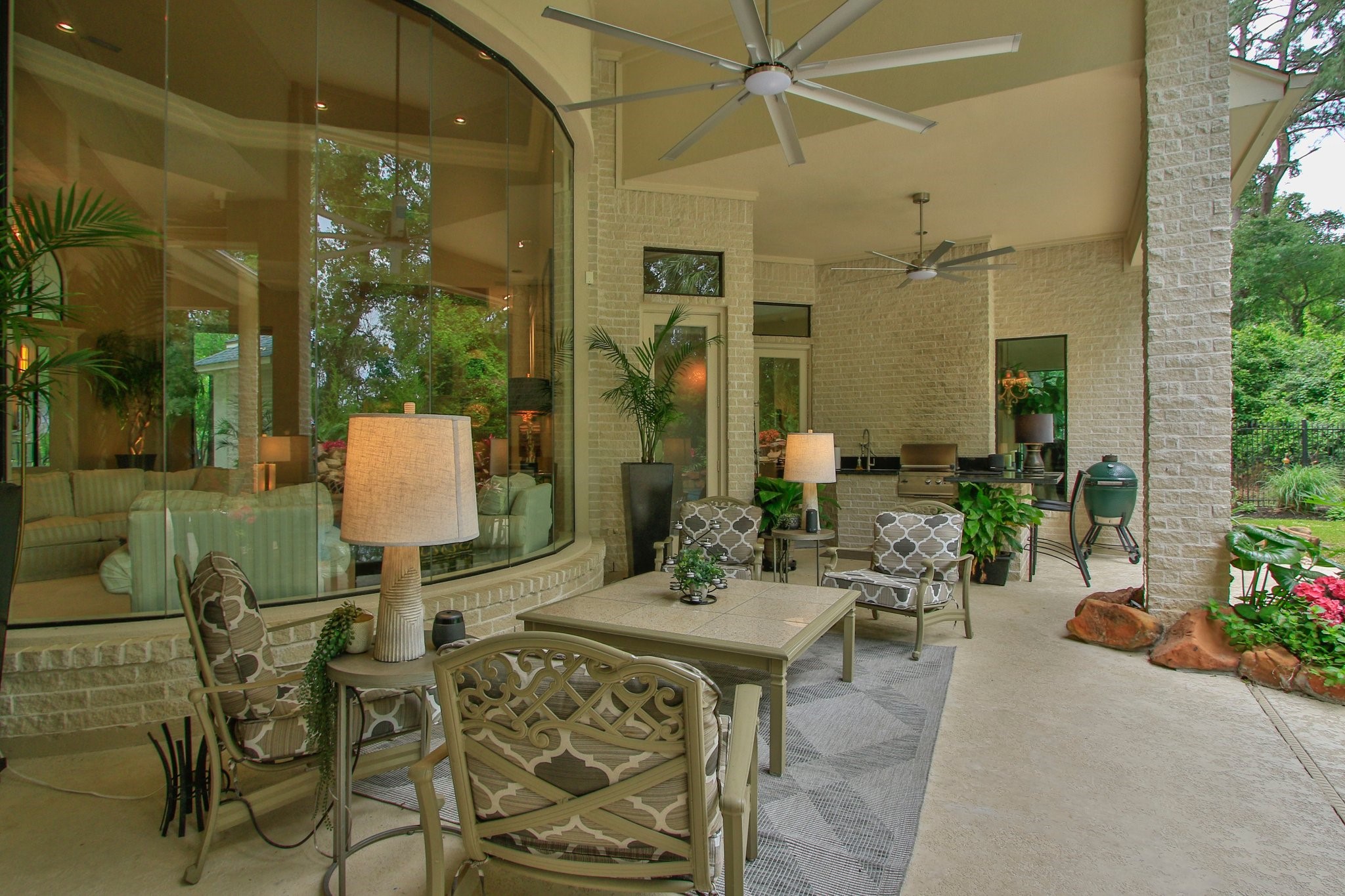 17511 Seidel Road Tomball, TX 77377 - Photo 10 of 49 Outdoor living at it's best! This photo showcases a spacious, covered patio with plenty of room for your outdoor furniture, ceiling fans, and lush greenery. The area features a built-in grill, providing a perfect space for entertaining and relaxing with a seamless indoor-outdoor flow.