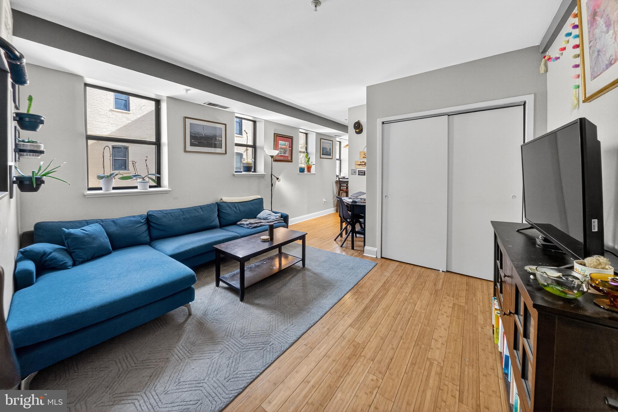 1440 W Street Northwest, Unit 304 Washington, DC 20009 - Photo 2 of 15 a living room with furniture a flat screen tv and a refrigerator