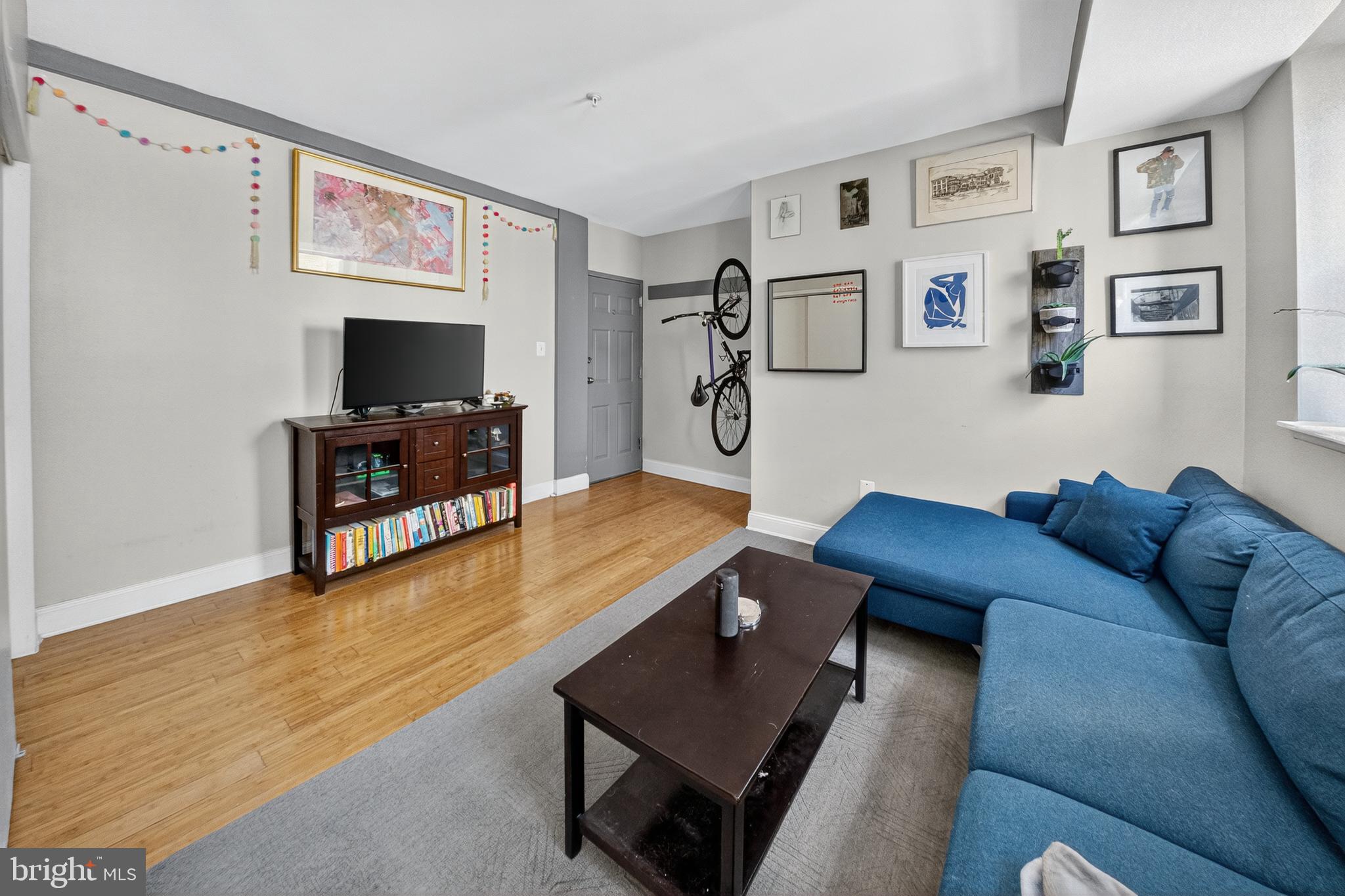 1440 W Street Northwest, Unit 304 Washington, DC 20009 - Photo 3 of 15 a living room with furniture and a flat screen tv