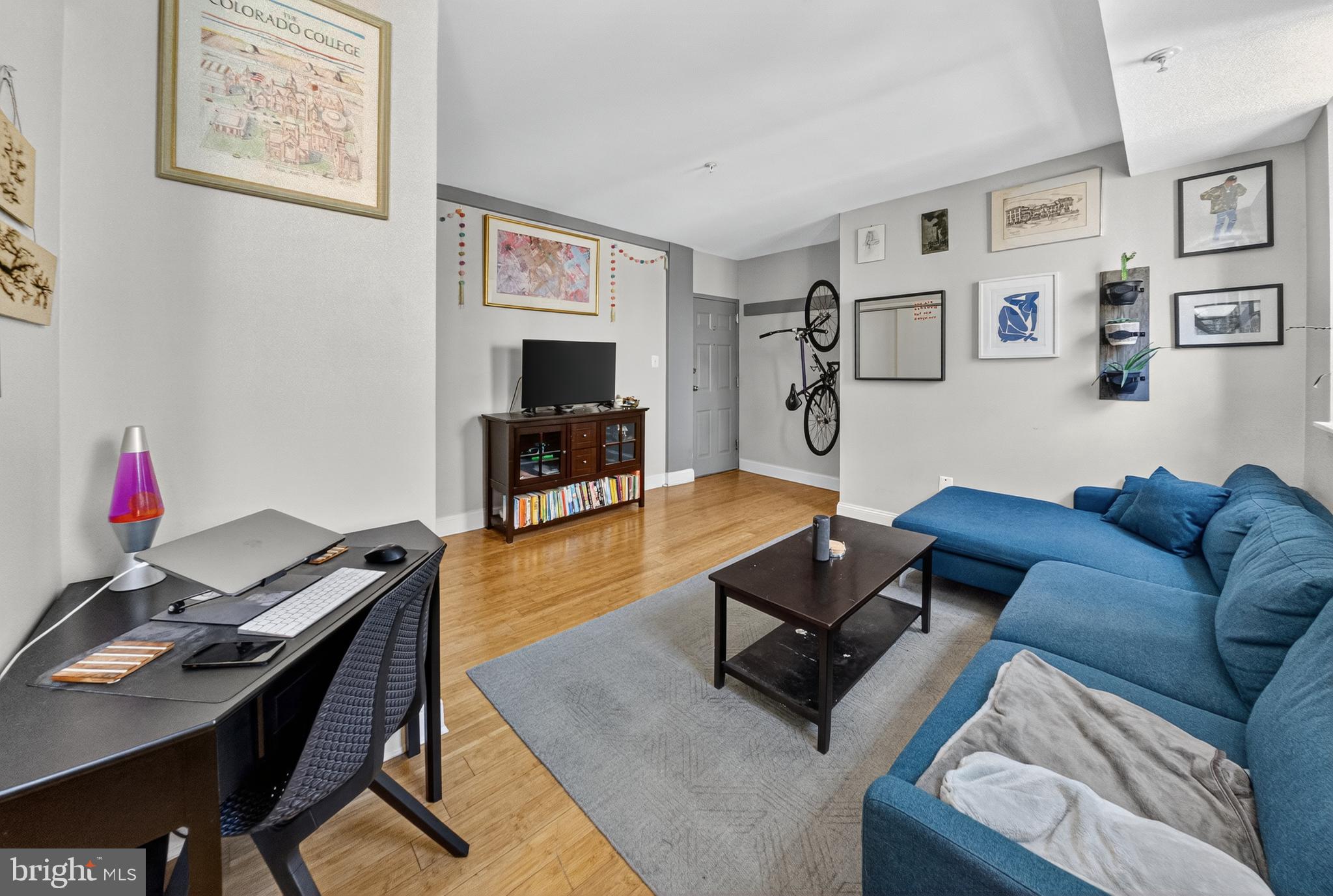 1440 W Street Northwest, Unit 304 Washington, DC 20009 - Photo 4 of 15 a living room with furniture a flat screen tv and a dining table