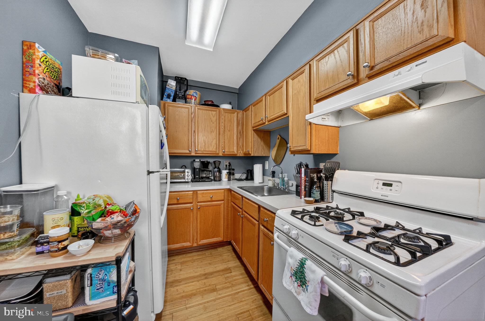 1440 W Street Northwest, Unit 304 Washington, DC 20009 - Photo 7 of 15 a kitchen with a stove a sink dishwasher and a refrigerator