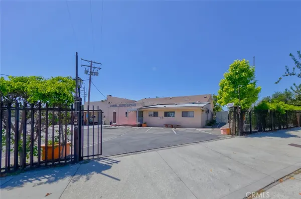 a view of a house with a yard and potted plants