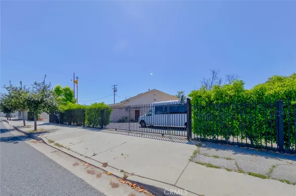 a view of a house with a yard and potted plants